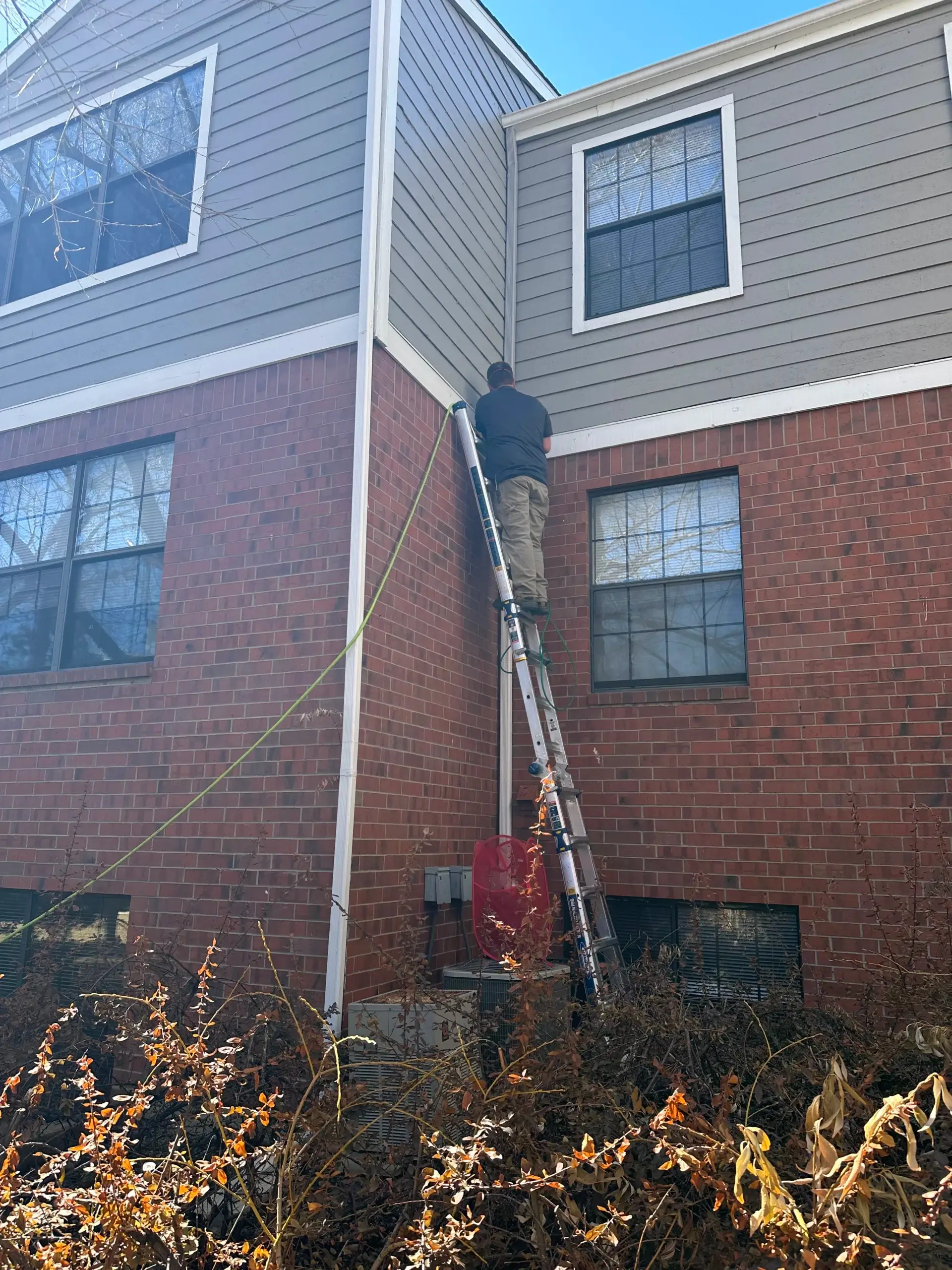 Dryer vent cleaning on ladder